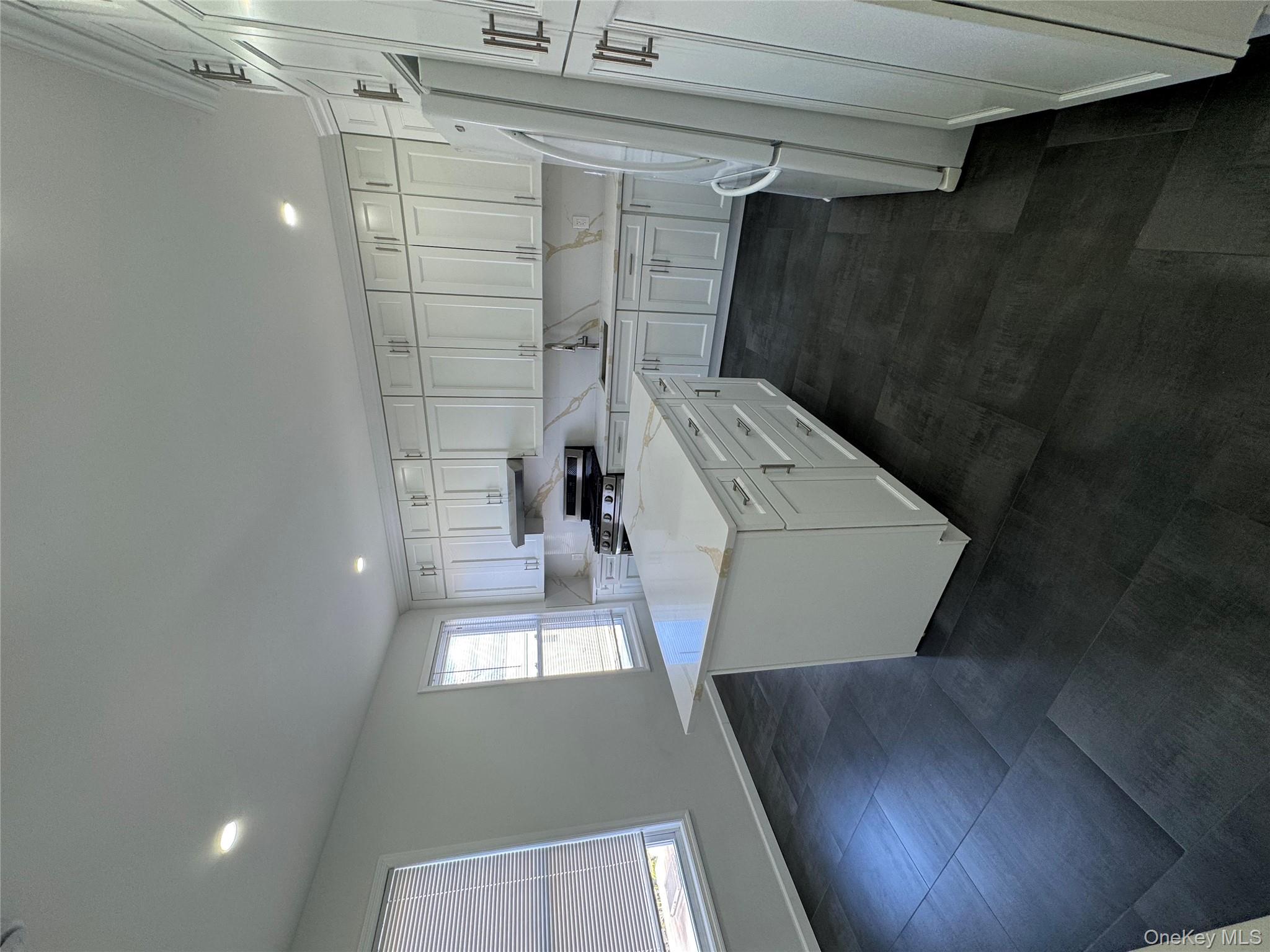 88-36 77th Street Queens, NY 11421 - Photo 5 of 19 a kitchen with a sink stove and cabinets
