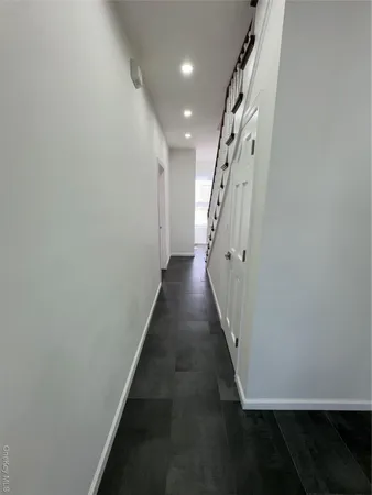 a view of a hallway with wooden floor and entryway