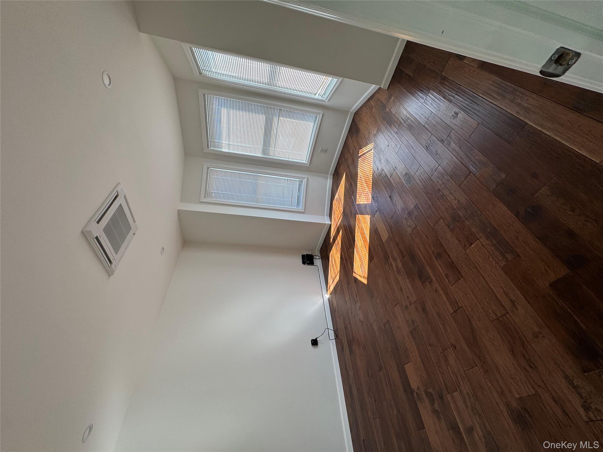 88-36 77th Street Queens, NY 11421 - Photo 10 of 19 a view of empty room with wooden floor and fan