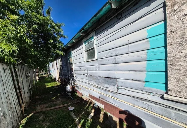a view of backyard with wooden fence and a window