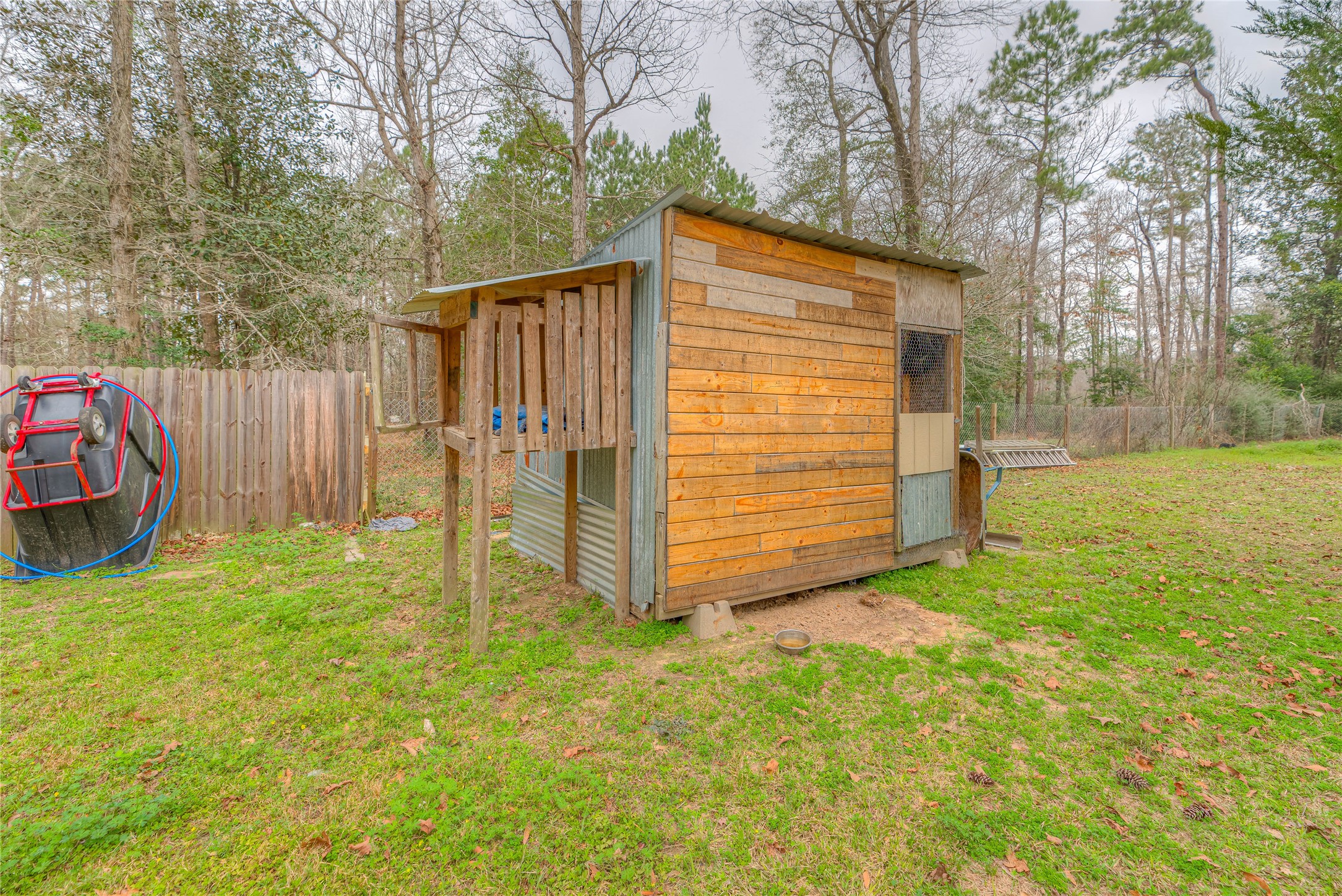 713 Garrett Road Livingston, TX 77351 - Photo 18 of 40 a view of backyard with small cabin and wooden fence