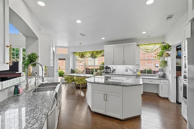 a kitchen with counter top space a sink appliances and living room view