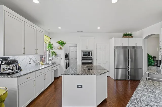 a kitchen with stainless steel appliances granite countertop a refrigerator sink and stove