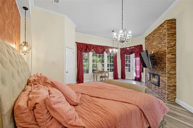 a bedroom with a large bed and a chandelier