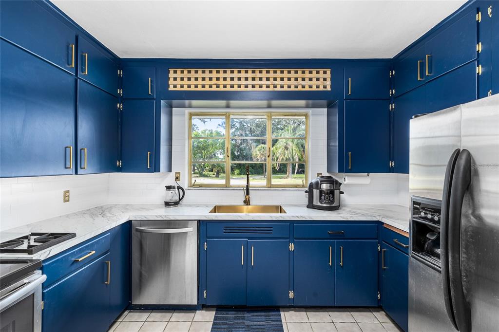 2027 Pinecrest Way Clearwater, FL 33755 - Photo 15 of 47 a kitchen with granite countertop a sink stainless steel appliances and cabinets