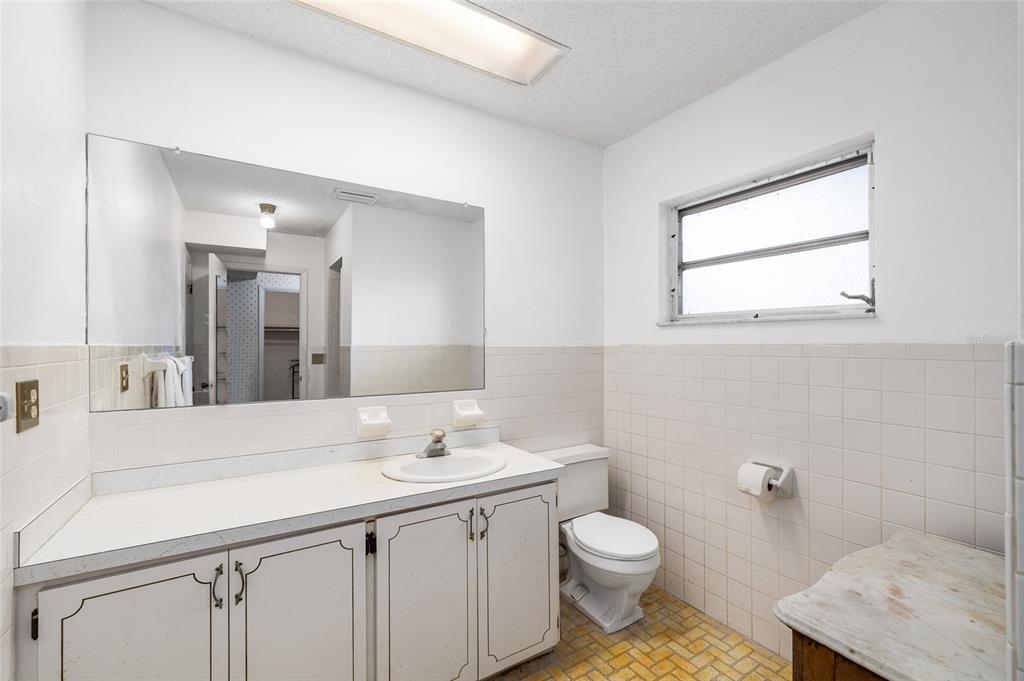 2027 Pinecrest Way Clearwater, FL 33755 - Photo 26 of 47 a bathroom with a toilet sink and mirror