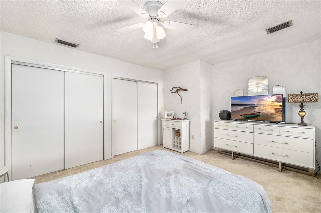 2027 Pinecrest Way Clearwater, FL 33755 - Photo 30 of 47 a spacious bedroom with a bed and a chandelier