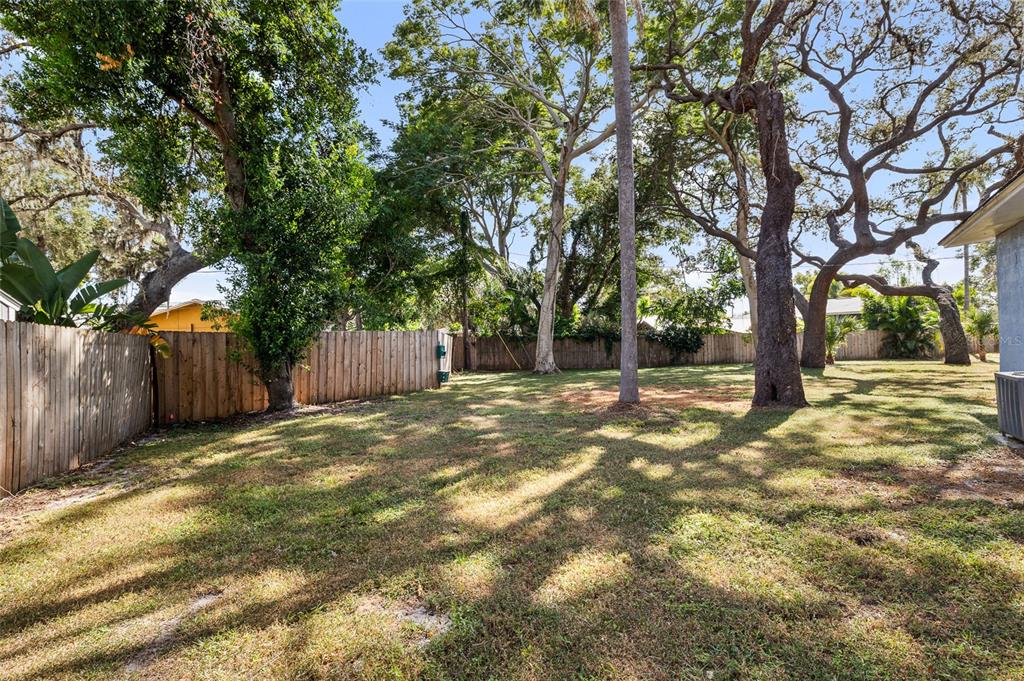 2027 Pinecrest Way Clearwater, FL 33755 - Photo 40 of 47 a backyard of a house with a trees and wooden fence