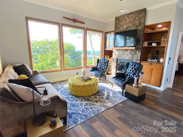 a living room with fireplace furniture and a large window