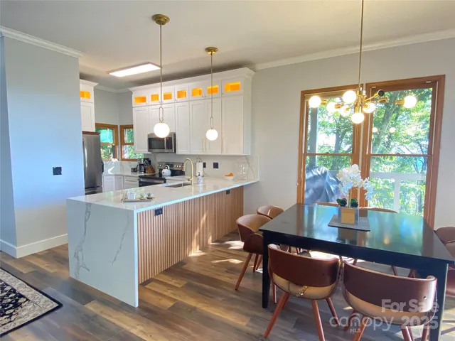 a kitchen with a dining table chairs appliances and cabinets