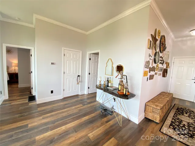 a view of a bedroom with wooden floor & ceiling fan