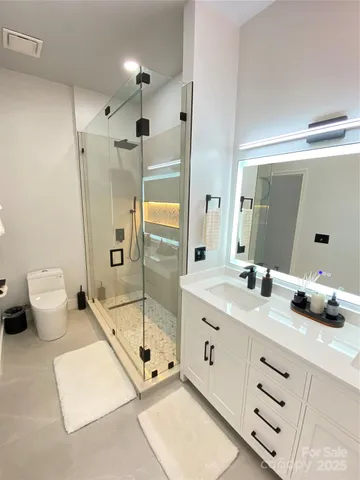 a bathroom with a double vanity sink toilet and shower