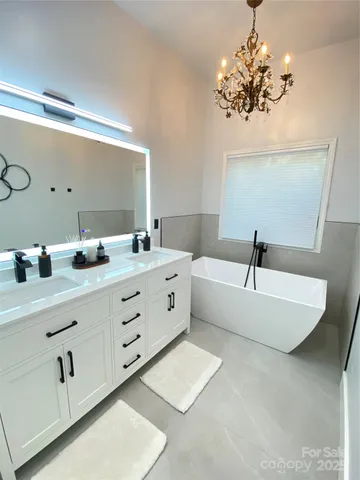 a bathroom with a double vanity sink mirror and bathtub