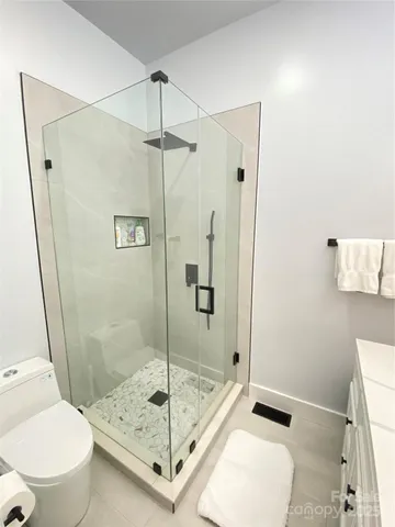 a bathroom with a shower a toilet and a sink