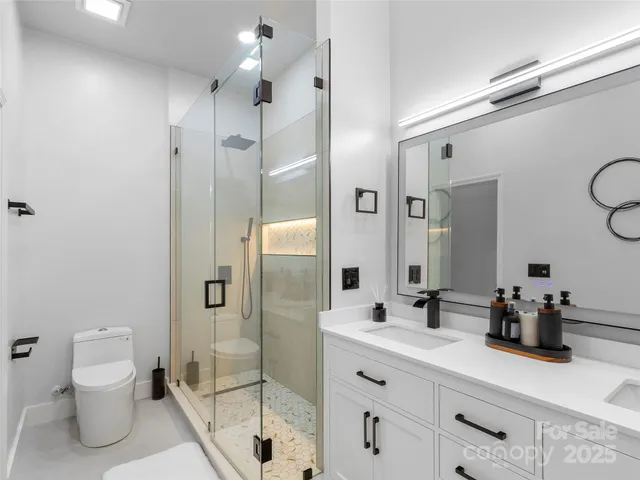 a bathroom with a double vanity sink toilet and shower