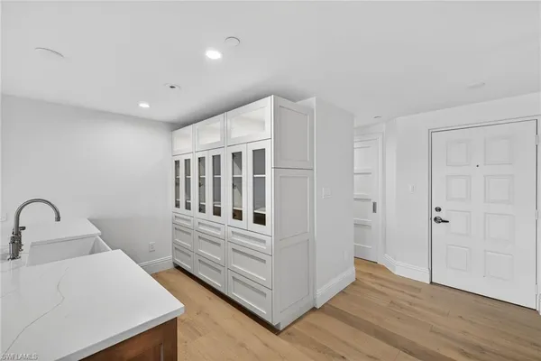 a view of a hallway with entryway a wooden floor and front door