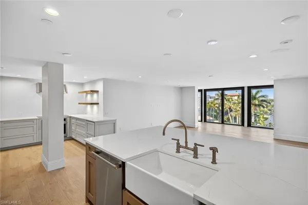 a kitchen with a sink a stove and a refrigerator with white cabinets