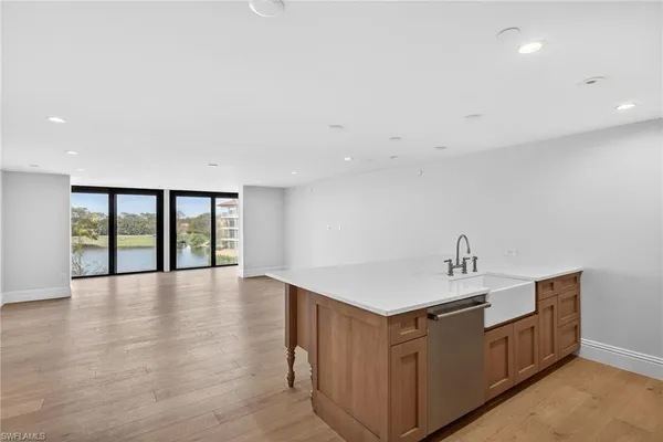 a kitchen with stainless steel appliances granite countertop a stove a sink and a refrigerator with wooden floor