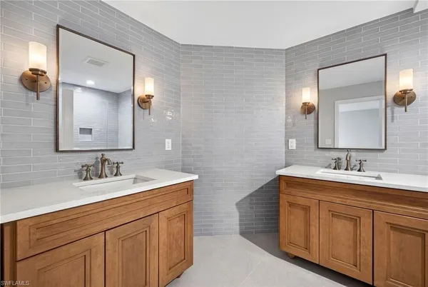 a bathroom with a double vanity sink and mirror