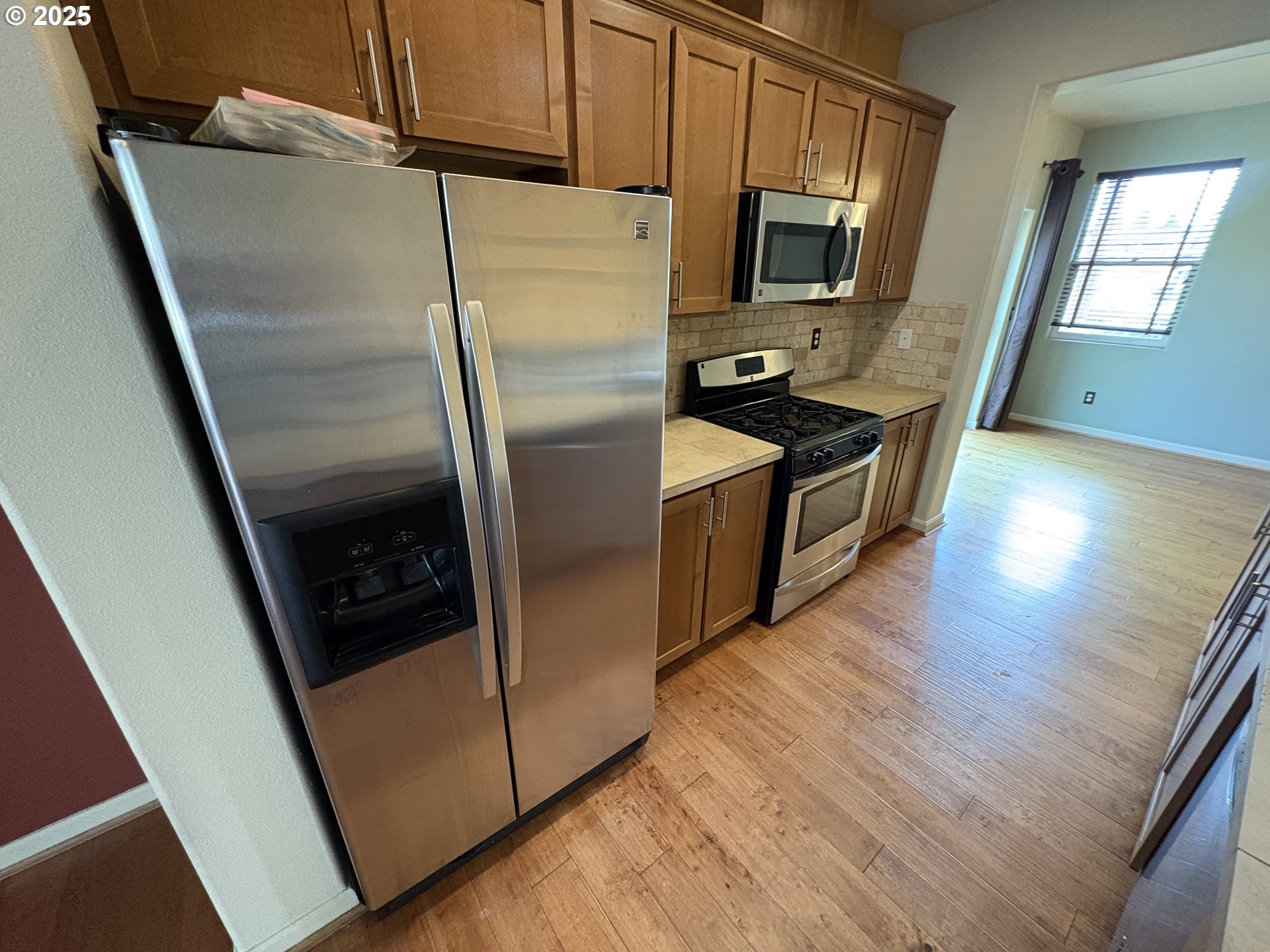 10552 Northeast Gateway Street Hillsboro, OR 97006 - Photo 9 of 41 a kitchen with stainless steel appliances and wooden floor