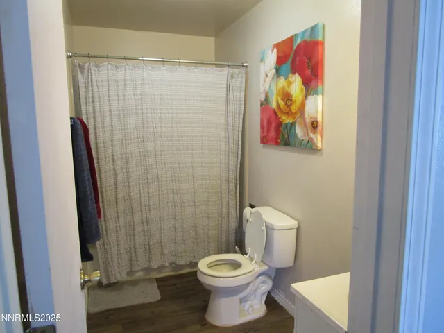 a bathroom with a toilet and a shower curtain