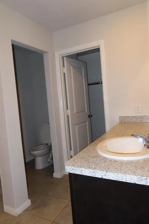 a bathroom with a granite countertop sink toilet and shower