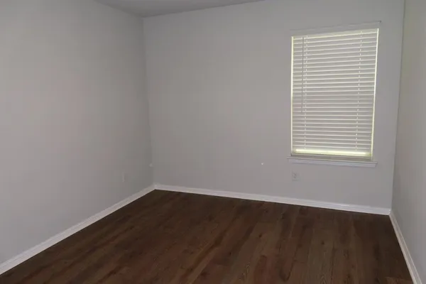 a view of a small space with wooden floor and a window