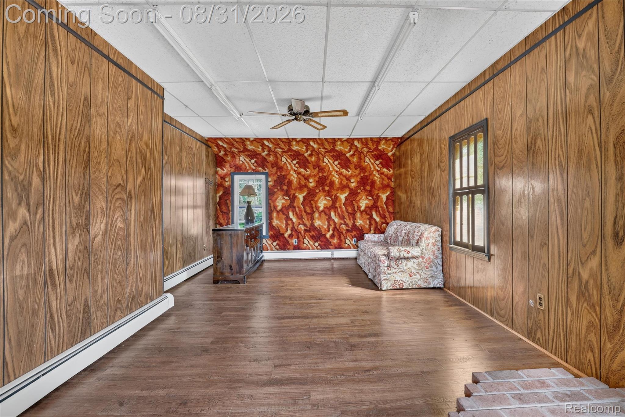 10165 Talladay Road Willis, MI 48191 - Photo 34 of 56 Wood-finish wall paneling, wood-finish flooring, drop ceiling with integrated lighting, ceiling fan, and a single window