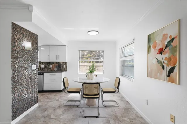 a living room with furniture a dining table and paintings on the wall