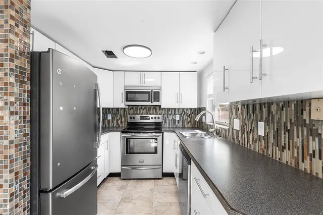 a kitchen with stainless steel appliances a stove sink and cabinets