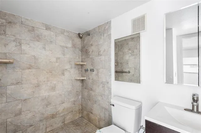 a bathroom with a sink a toilet and shower