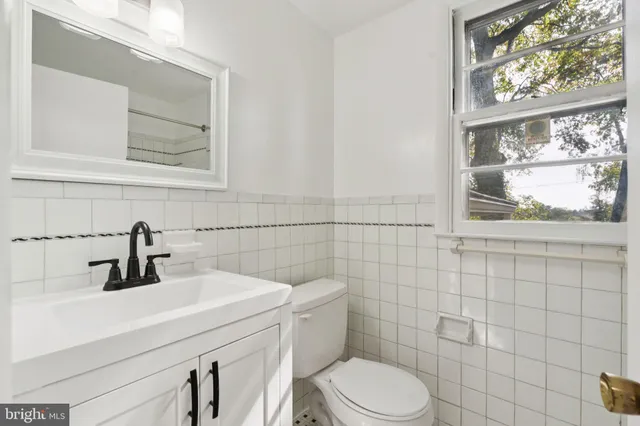 a bathroom with a sink a toilet and a window