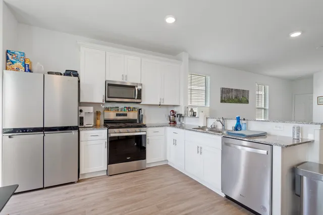 a kitchen with stainless steel appliances granite countertop a refrigerator sink and stove