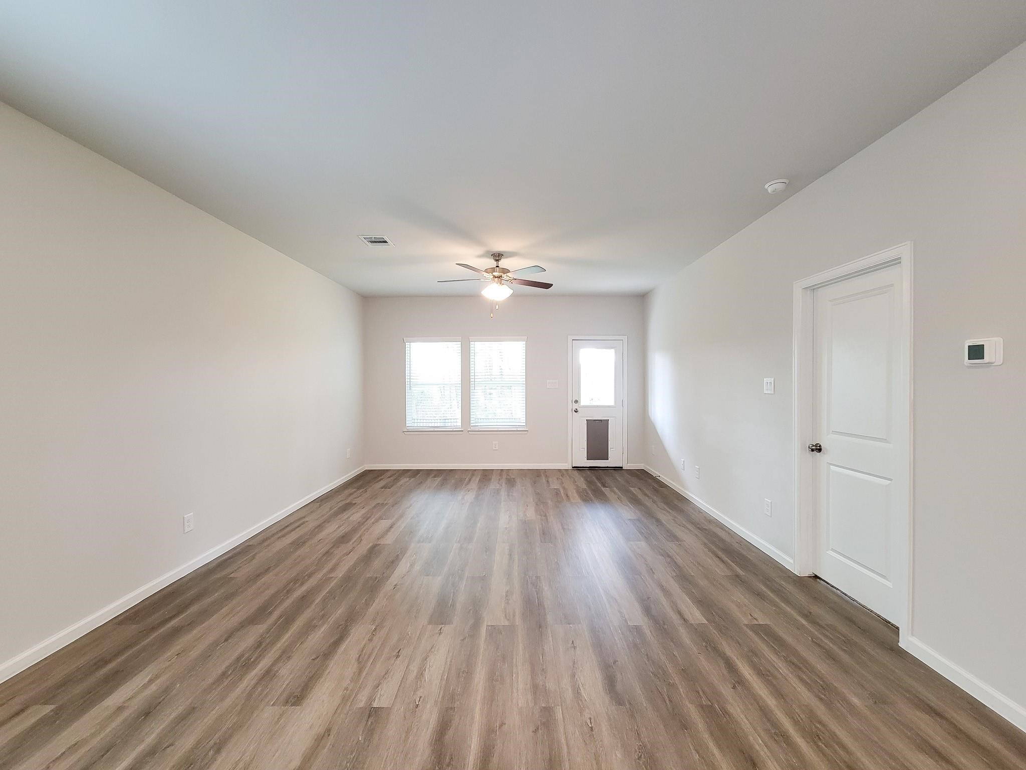 94 Valiant Ridge Trail Magnolia, TX 77354 - Photo 11 of 47 an empty room with wooden floor and windows