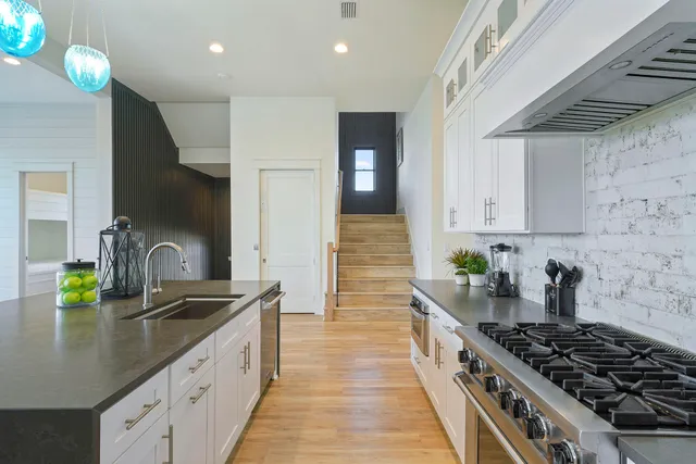 a kitchen with sink a stove and cabinets