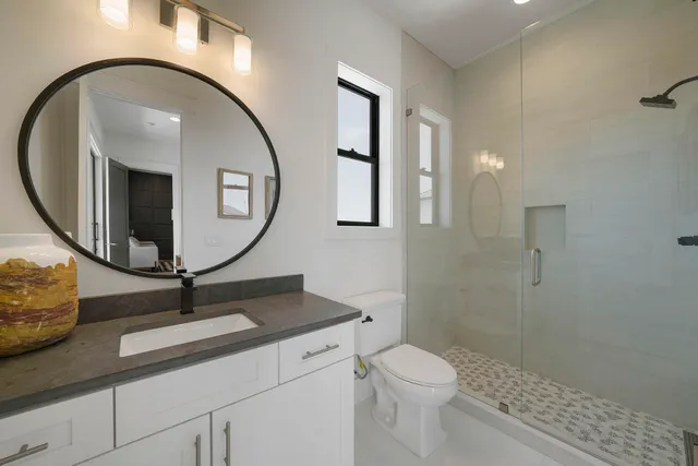 a bathroom with a toilet a sink and mirror