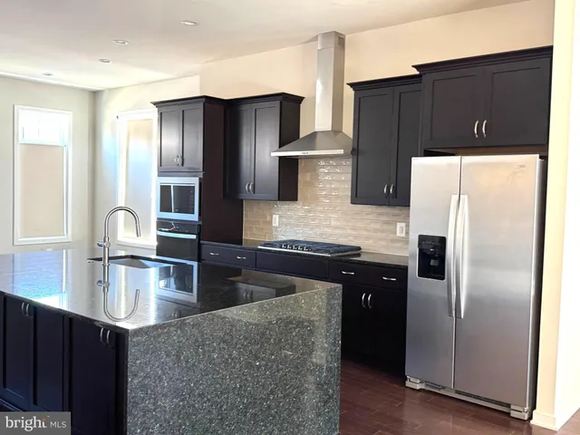 a kitchen with stainless steel appliances granite countertop a refrigerator and a stove