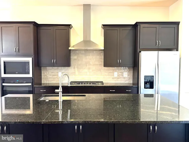 a kitchen with granite countertop a refrigerator and a stove