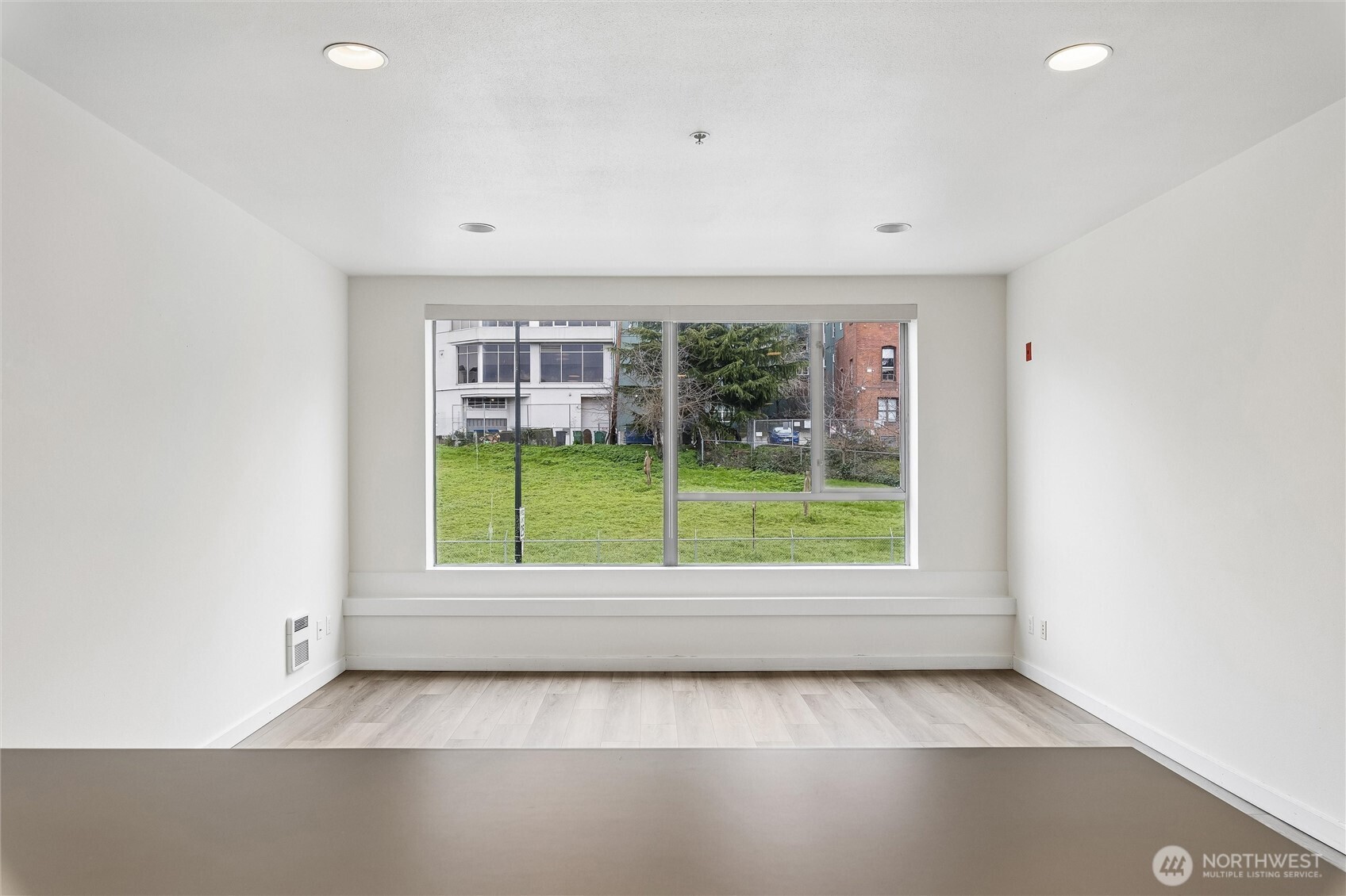 66 Bell Street, Unit 23 Seattle, WA 98121 - Photo 12 of 24 an empty room with a fireplace and large window
