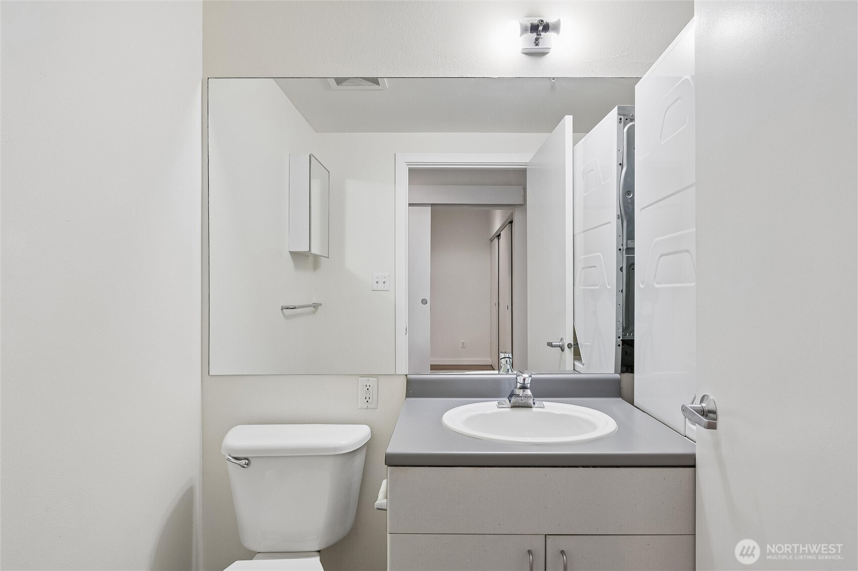 66 Bell Street, Unit 23 Seattle, WA 98121 - Photo 17 of 24 a bathroom with a toilet sink and mirror