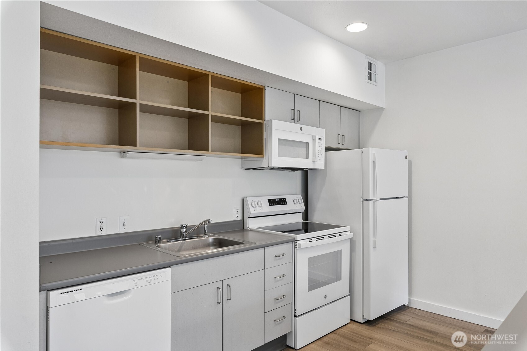 66 Bell Street, Unit 23 Seattle, WA 98121 - Photo 10 of 24 a kitchen with stainless steel appliances a sink a stove a refrigerator and cabinets
