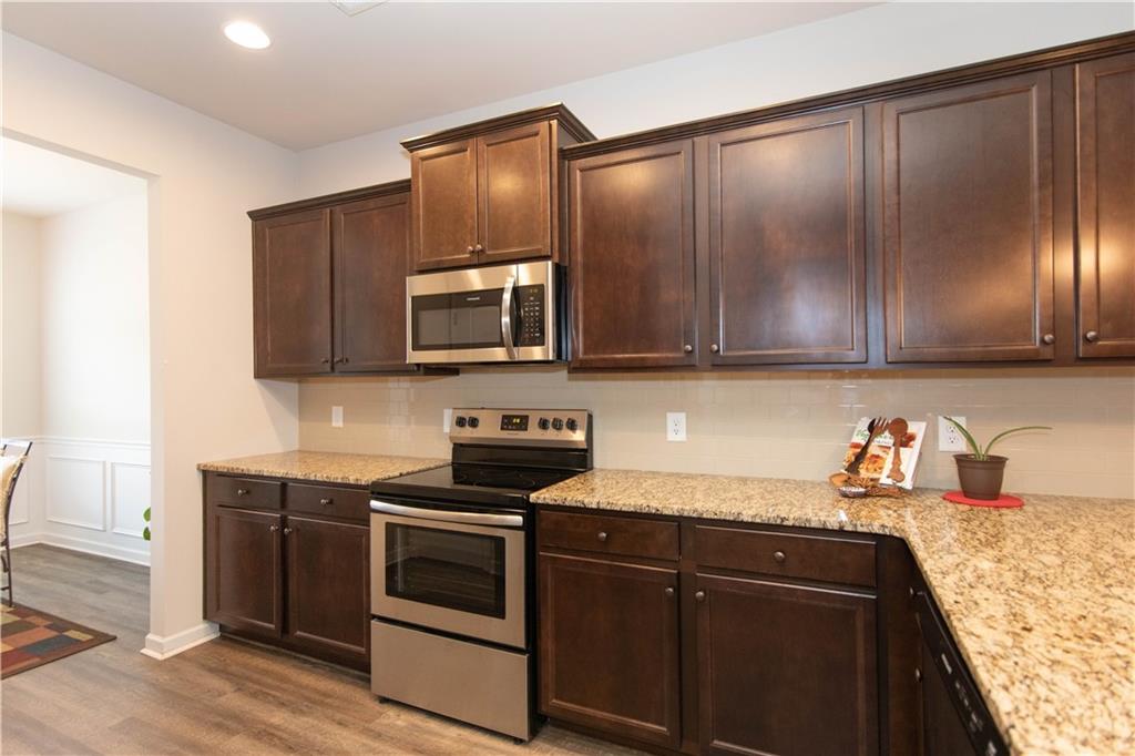 103 Prominence Court Canton, GA 30114 - Photo 7 of 34 a kitchen with granite countertop cabinets stainless steel appliances and wooden floor