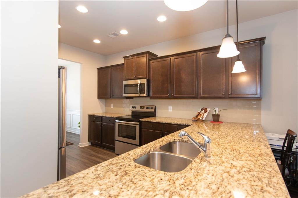 103 Prominence Court Canton, GA 30114 - Photo 8 of 34 a kitchen with stainless steel appliances granite countertop a sink refrigerator and microwave