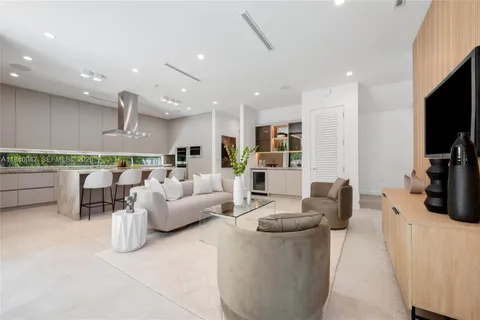 a living room with furniture potted plant and a large window