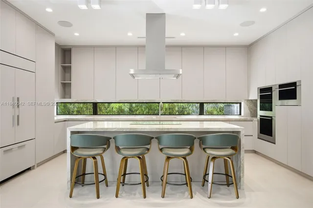 a dining room with furniture large windows and wooden floor