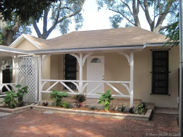 a front view of a house with a yard and potted plants