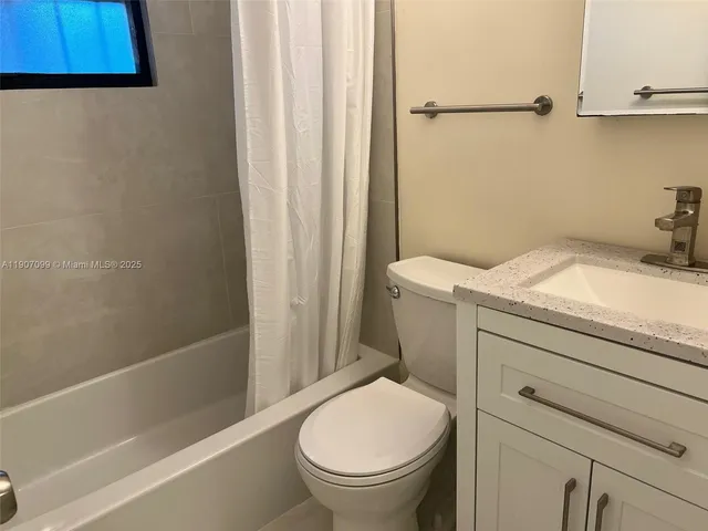 a bathroom with a granite countertop sink toilet and a bathtub