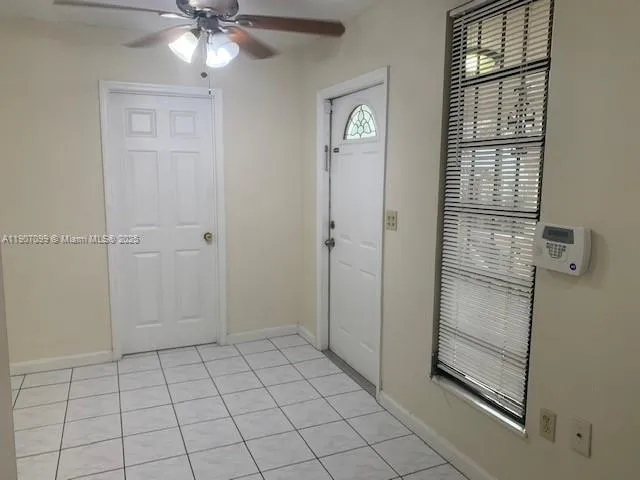 a view of an empty room with chandelier fan