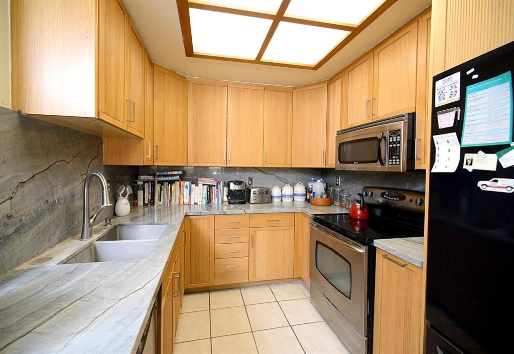 a kitchen with granite countertop a stove a sink and a microwave