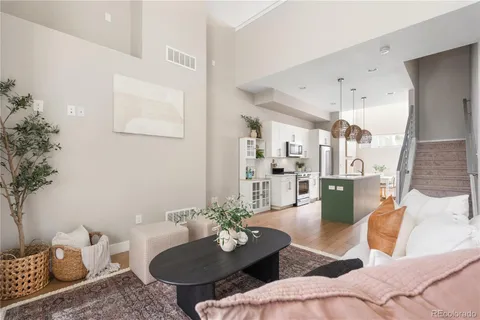 a living room with furniture kitchen view and a potted plant